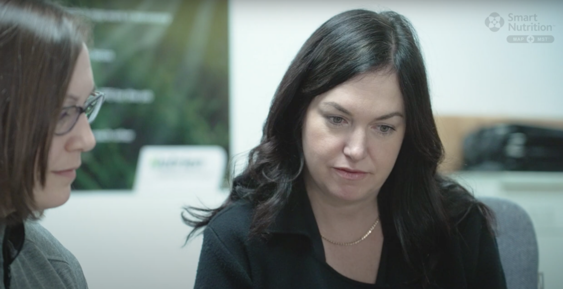 Nutrien representative Amy Crozier speaking with retailer Brett Elko while looking at computer screen.